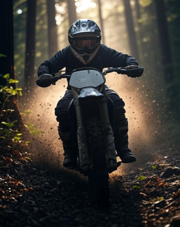Person riding a motorcycle through a forest with sunlight filtering through the trees.